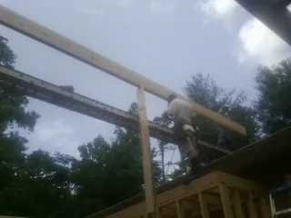Carpenter setting a ridge beam over a new addition frame — Ice Dam Removal by Roofing Brothers in Gonvick
