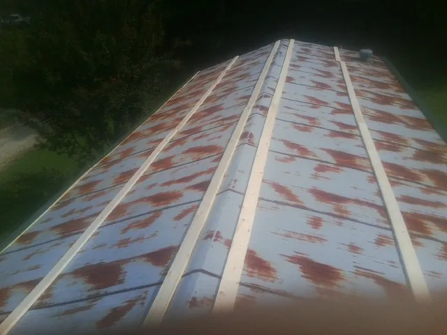 Rusted metal roof panels with new wood purlins before replacement — Storm Damage Roof Repair in Gonvick by Roofing Brothers